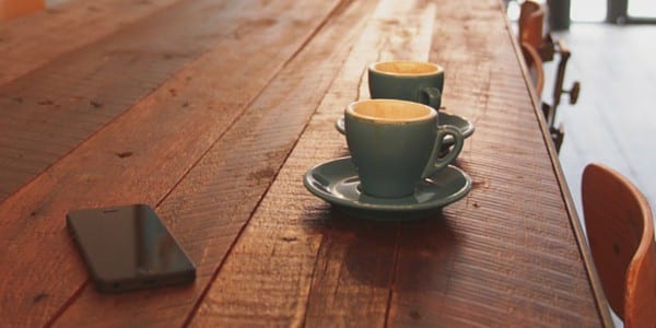 Cafe table with phone and two coffee cups