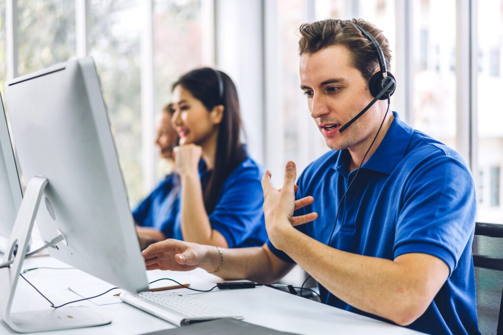 Group of happy live receptionist call center smiling business operator customer support team phone services agen working and talking with headset on desktop computer at call center