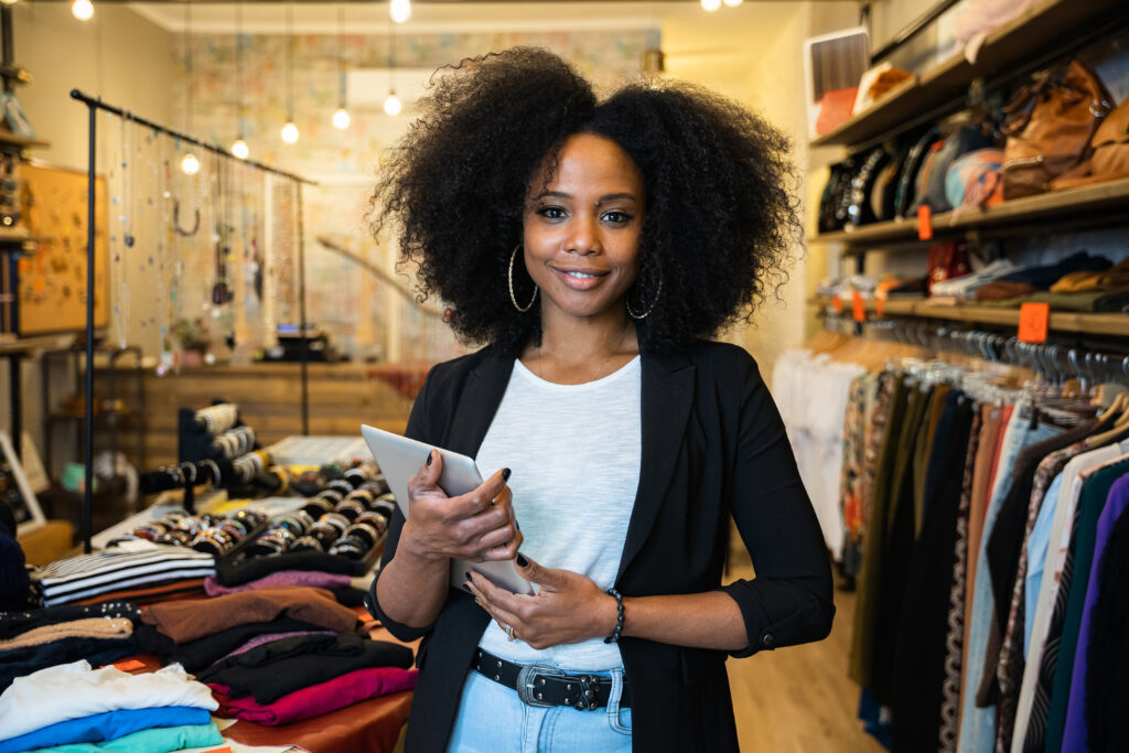 Portrait of the owner of a clothing store at the entrance of the