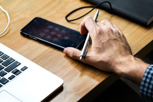 Man collecting phone from desk